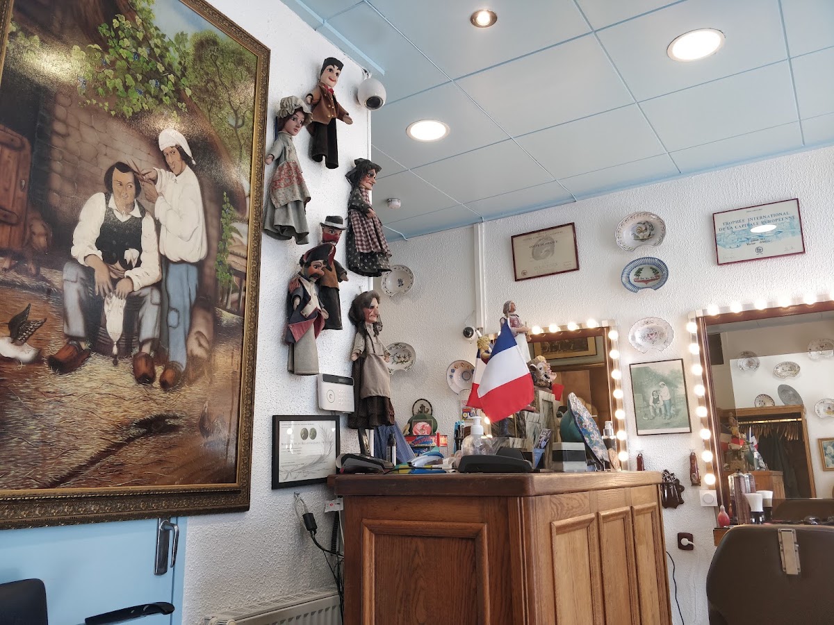 Le mur du comptoir, avec une collection de marionnettes de Guignol et une peinture ancienne représentant un barbier.